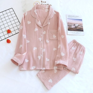 Vue détaillée du pyjama en crêpe de coton rose à cœurs avec col à revers et passepoil blanc