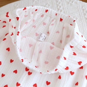 Close-up of cotton gauze pajama waistband with red hearts and 100% cotton size label