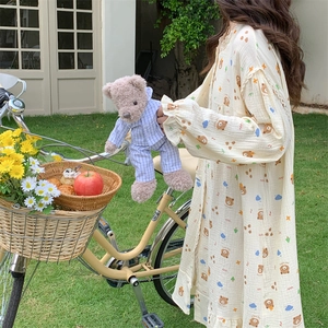 Beige bear print long sleeve pajama dress with ruffle cuffs in a garden setting