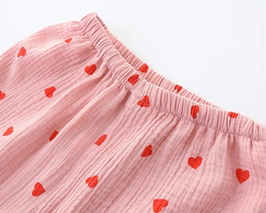 Detail of pink muslin cotton pajama pants with red heart print and elastic waistband