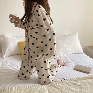 Detail of soft cotton gauze pajamas with heart print and red contrast piping edge