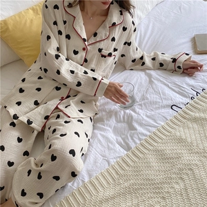 Detail of soft cotton gauze pajamas featuring heart prints and red contrast piping accents