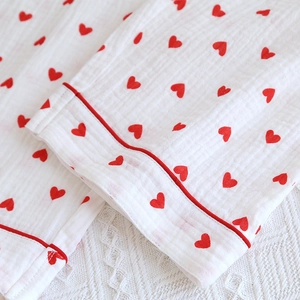 Close-up of soft double-layer cotton gauze pajamas with red heart prints and piping