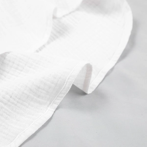 Detailed macro view of white double-layer muslin fabric with woven checkered texture