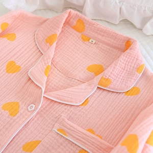 Détail du pyjama à cœurs roses montrant le tissu froissé et les boutons en forme de fleur