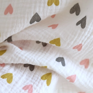 Detailaufnahme aus weichem Baumwoll-Musselin mit buntem Herzmuster-Drucktextur