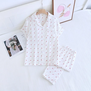 Détail du tissu de pyjama en double gaze de coton avec motifs de cœurs rouges et boutons