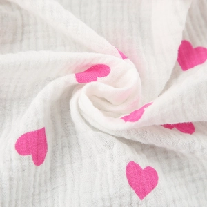 Détail du tissu en mousseline de coton respirant avec imprimé cœur doux pour bébé