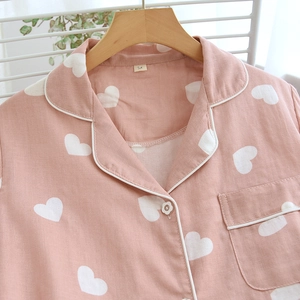 Women's pink short sleeve cotton pajamas with white heart prints and floral buttons