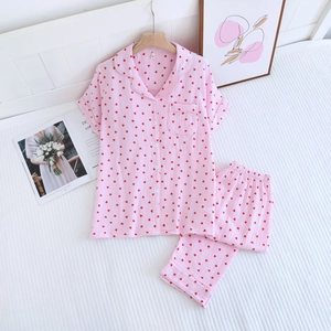 Détail d'un pyjama en coton rose avec motifs de cœurs rouges et haut à manches courtes