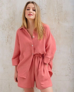 Detail of coral pink crepe loungewear set showing breathable fabric and white buttons