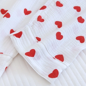 Gros plan sur le tissu en coton blanc d'un pyjama avec motifs de cœurs rouges