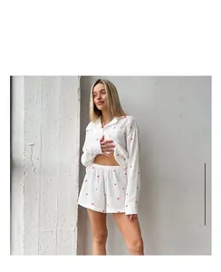 Détail de l'imprimé à cœurs rouges sur le pyjama à manches longues en coton blanc
