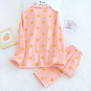 Détail d'un pyjama en gaze de coton rose avec motifs de cœurs jaunes et liserés blancs