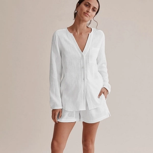 White cotton gauze pajama set with long sleeve button-up top and matching shorts for women