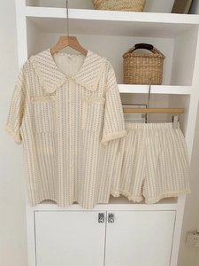 Detail of retro tassel edges on beige striped short-sleeve pajama shirt and shorts set