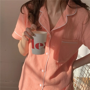 Detail view of pink cotton gauze pajama top with white piping and lapel collar