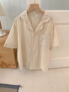 Detailed view of beige short sleeve pajama shirt with black vertical stripes and dots