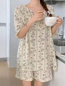 Detail of summer floral pajama set featuring a lace-up neckline and vintage prints