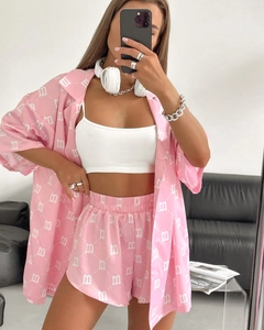Detailed view of pink three-piece set with shirt, printed shorts, and white halter top