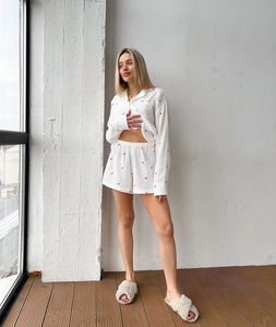 Détail du pyjama en coton blanc avec motif cœur rose et texture de tissu respirant