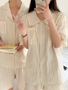 Close-up of tassel edges and striped cotton fabric on minimalist pajama set