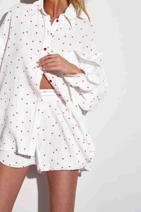 Dettaglio completo del set due pezzi in cotone bianco con stampa a cuori rossi e tessuto