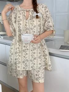 Detail of cream floral pajama set with lace-up neckline and ruffle sleeve decoration
