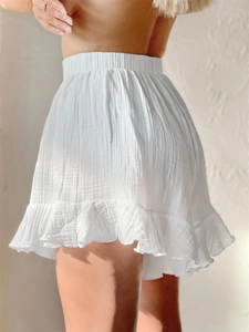 Detail of white cotton crepe high-waisted ruffled shorts with elastic waist and soft texture