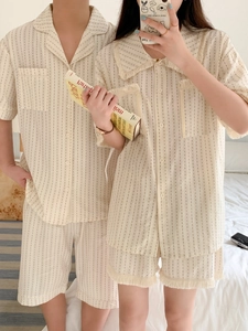 Detail view of cotton couple pajamas with stripes and polka dots in a bedroom setting