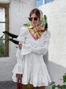 Dettaglio vestito bianco in pizzo sangallo con scollo a V, maniche a sbuffo e foulard