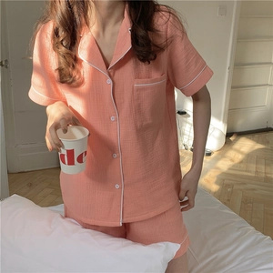 Detail of coral gauze pajama set with white piping and textured cotton fabric