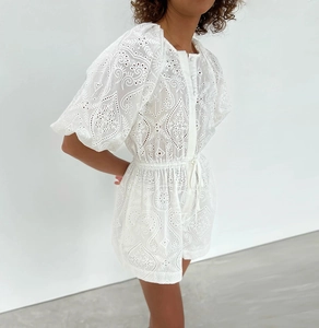 Détail de la broderie blanche ajourée sur une combinaison courte d'été en coton