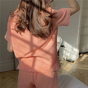 Detail of coral gauze pajama shorts set with soft textured fabric and white piping trim