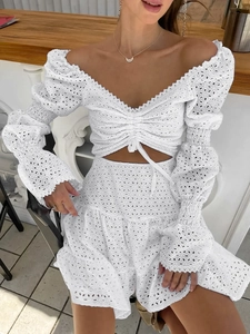 Dettaglio di un set bianco in pizzo sangallo con top a scollo a V e gonna con volant
