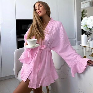 Detail of pink cotton muslin robe featuring ruffled sleeves and a textured tie-waist