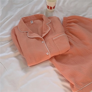 Detail of peach cotton gauze pajama set with white piping on collar and buttons