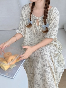 Detail of floral loungewear featuring V-neck ties and delicate ruffle sleeve cuffs