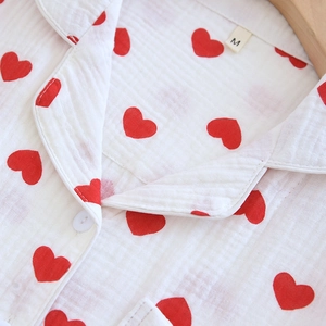 Détail du haut de pyjama blanc à motif cœurs rouges avec texture du col à revers