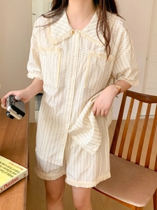 Detail of cream striped pajamas featuring distressed raw edge tassels on cuffs and collar