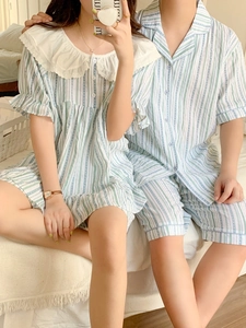 Gros plan d'un couple en pyjamas assortis à rayures bleues et blanches sur un lit