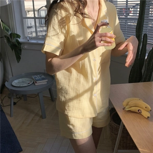 Detail of light yellow gauze pajama set showing soft cotton texture and white piping