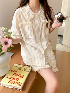 Detail of short sleeve cream pajama shirt featuring fringe trim and subtle pinstripes