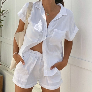 Detail of white linen two-piece set featuring short-sleeve shirt and drawstring shorts