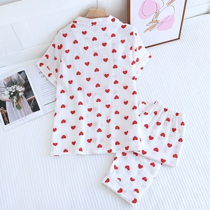 Mise à plat d'un pyjama doux en coton blanc avec motifs cœurs rouges et manches courtes