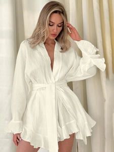 Detail of white cotton crepe fabric texture with romantic ruffled sleeves and tie-waist