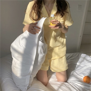 Detailed view of yellow crepe pajamas featuring white piping and high-quality fabric texture