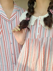 Détail d'un pyjama à rayures rouges et blanches avec points bleus et col en dentelle