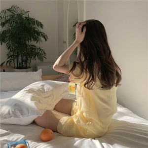 Close-up of yellow gauze pajamas with a soft crinkle texture on a sunny bed