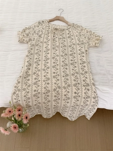 Detail of short sleeve floral summer dress with lace-up neckline and ruffle sleeves